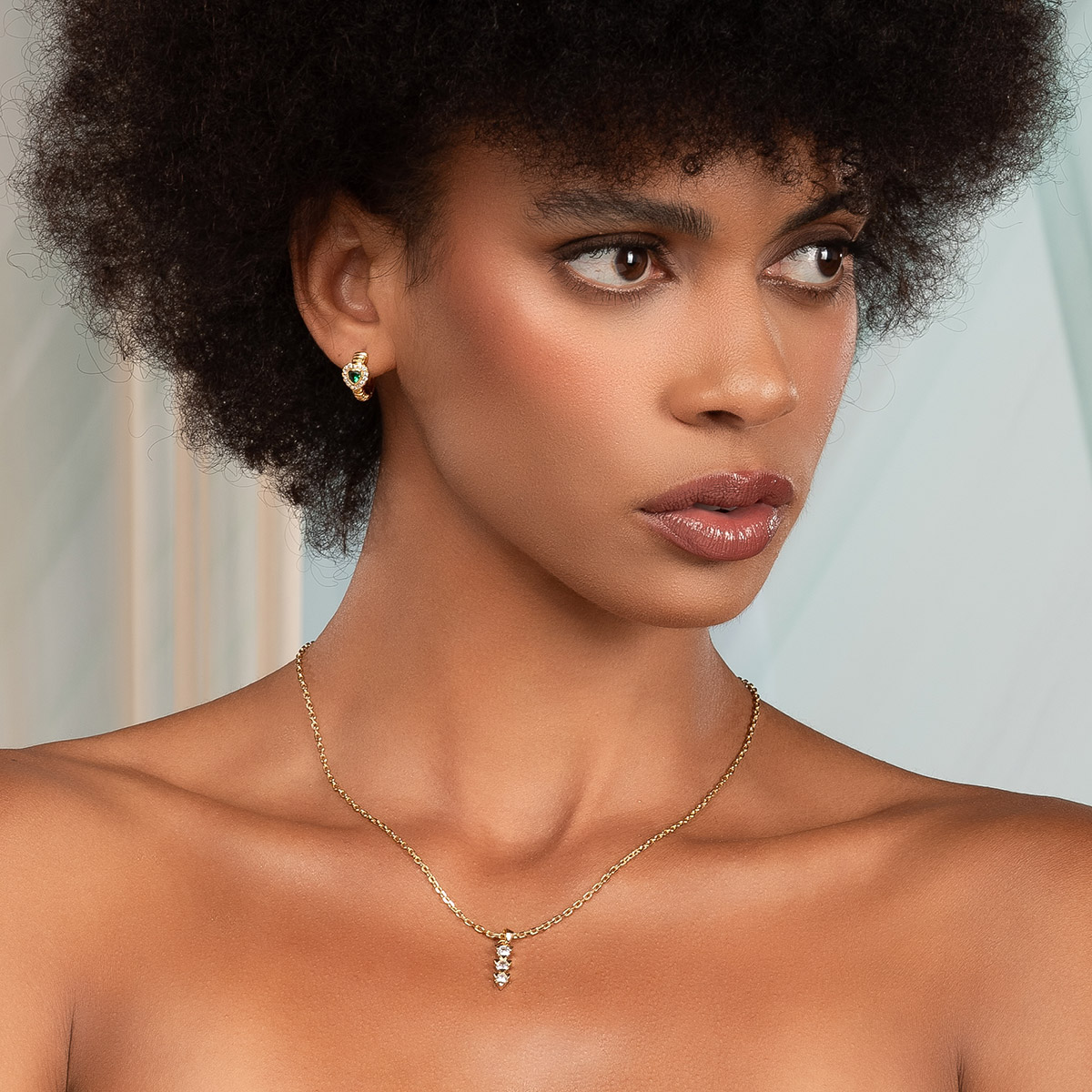 Aretes en baño de oro con corazón verde y contorno brillante